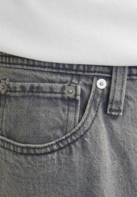 Gray denim jeans with silver hardware. Features a front pocket, visible stitching, and a subtle texture.