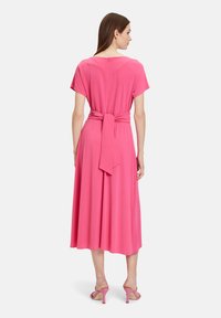 Rosa, kleid mit knielanger Länge, kurzen Ärmeln, einem gebundenen Taillendetail und einer glatten Textur. Hoher Kragen mit einem Reißverschluss auf der Rückseite.