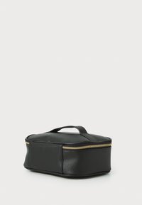Funda negra con zipper hecha de material texturizado, con un mango resistente y un acento de zipper dorado. Forma rectangular, diseño compacto.