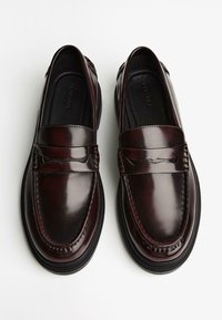 Dark burgundy leather loafers with a smooth finish, featuring a stitched accent and a slightly raised sole for added comfort.