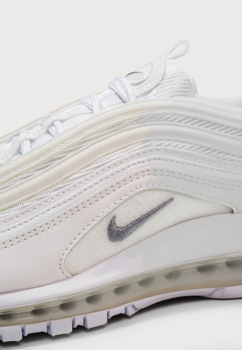 Gros plan sur une sneaker Nike Air Max blanche montrant les détails en maille, en cuir, les coutures, le lacet, la languette et la semelle avec amorti visible.