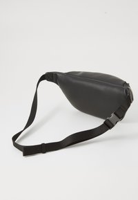 Borsa in pelle nera elegante con cintura nera regolabile e fibbia in plastica su uno sfondo bianco semplice.