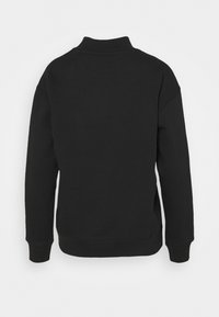 Sudadera negra con un cuello alto, mangas largas y puños acanalados. Textura suave con un corte holgado, con un mínimo de detalles en la parte trasera.