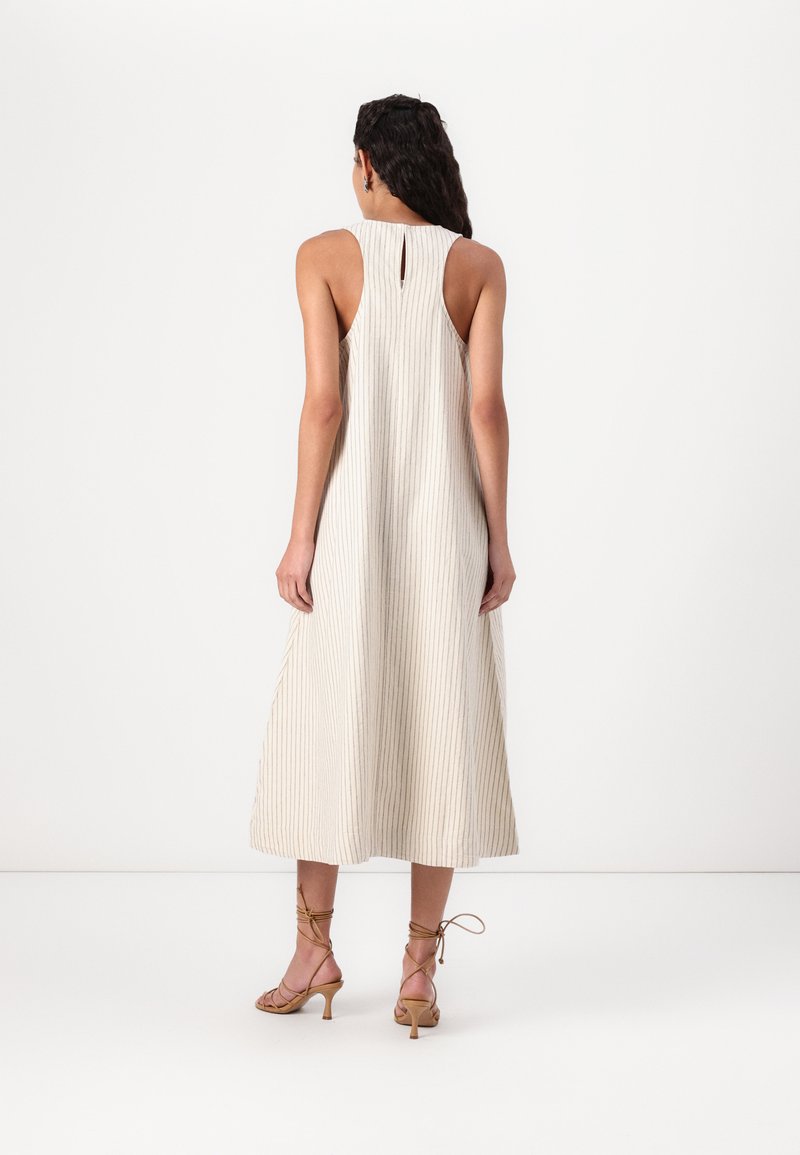 Ärmelloses beiges Midikleid mit vertikaler Rippstruktur. Merkmale sind ein Rückenausschnitt, eine fließende Silhouette und ein Saum, der unterhalb der Waden endet.