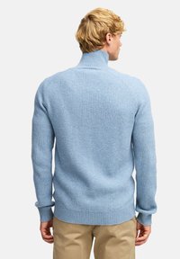 Jasnoniebieski sweter z prążkowanym wzorem, z wysokim kołnierzem, teksturowanym splotem i dopasowanymi mankietami. Posiada gładkie wykończenie oraz lekko tapered krój w talii.