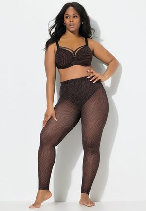 Zwart en bruin zebra-print bralette en hoge taille leggings. De beha heeft beugels en verstelbare bandjes; de leggings zijn doorschijnend met een gestructureerd patroon.