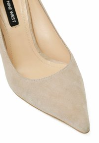 Beige semišové lodičky na vysokém podpatku s špičatou špičkou, obsahující hladké vnitřní podšívky, nízký vykrojený svršek a jemné švy.