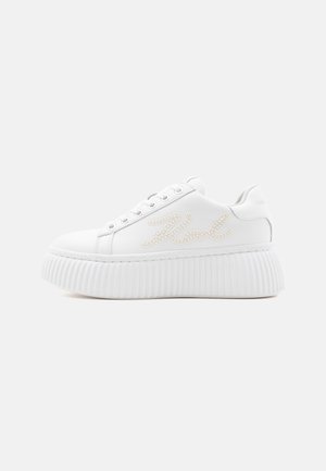 Άσπρο πλατφόρμα sneaker με ανάγλυφη σόλα, κορδόνια μπροστά και διακόσμηση με μαργαριτάρια που σχηματίζει καλλιγραφικό κείμενο στο πλάι.