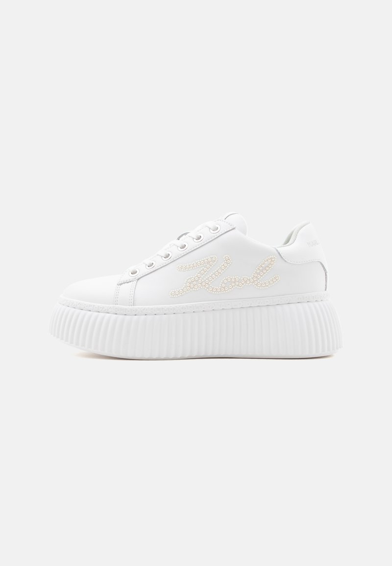 Άσπρο πλατφόρμα sneaker με ανάγλυφη σόλα, κορδόνια μπροστά και διακόσμηση με μαργαριτάρια που σχηματίζει καλλιγραφικό κείμενο στο πλάι.