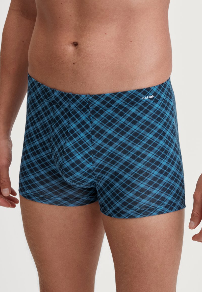 Boxer shorts à carreaux bleus et noirs en tissu extensible. Présentent une coupe ajustée, une taille lisse et des lignes diagonales sur le motif.