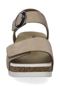 Beige sandaal met een brede band, zilveren gesp, kurk-textuurzool en een soepel voetbed met witte accenten.