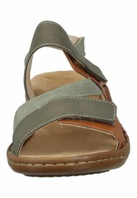 Brown and green sandals with a cross-strap design, made of leather and suede. Features a cushioned footbed and stitched edges.