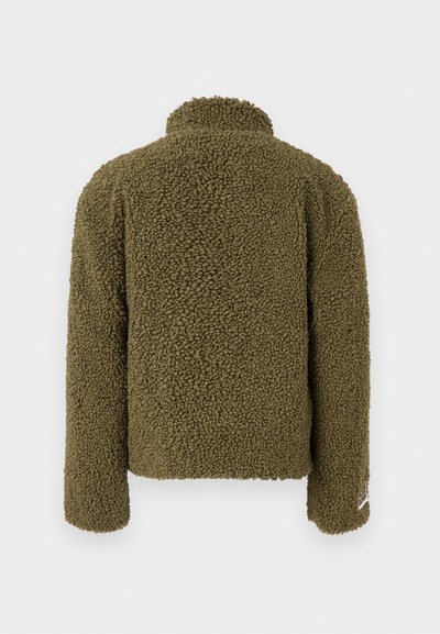 Olive green fuzzy fleece jacket with a high collar, textured surface, long sleeves, and a small brand label at the bottom left side.
