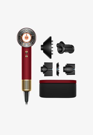 Roter und goldener Haartrockner mit transparentem, rundem Kopf, vier schwarzen Styling-Aufsätzen und rechteckiger schwarzer und roter Aufbewahrungsbox vor weißem Hintergrund.