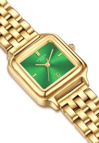 Kuldne ruudukujuline kell rohelise päikesekiire dial'iga, kaks kuldset tunni näitajat ja reljeefne kuldne käevõru lukuga kinnitusega.