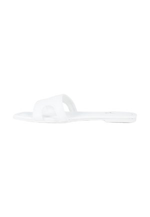 Sandalo piatto bianco singolo con una larga fascia sulla parte superiore e design a punta aperta su uno sfondo semplice.