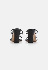 Sorte høyhælte sandaler med stropper, med et glatt skinnoverdel og en solid blokkhel. Åpen tå-design med en minimalistisk estetikk.