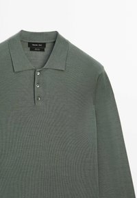 Green knit long-sleeve polo shirt made from 100% wool. Features a collared neckline and three-button placket, with a textured finish.