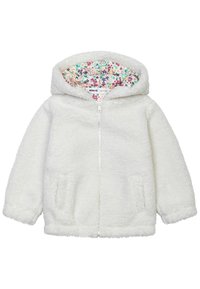 Bílá fleecová bunda s kapucí, předním zipem a dvěma bočními kapsami. Vnitřní podšívka má květinový vzor v růžové, zelené a modré barvě.