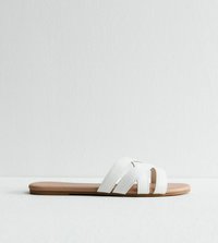 Sandale blanche à semelle plate en cuir beige, avec un design à trois lanières croisées et des détails de couture subtils.