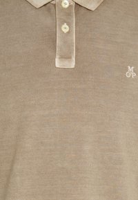 Beige polo shirt van gestructureerde stof met een drieknopshuis en klein geborduurd "MOP" logo. Veilige knoopsluiting bij de kraag.