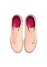 Nike Phantom GX football boots in soft peach with black logo, textured upper, and vibrant pink interior. Laces and low-profile design included.