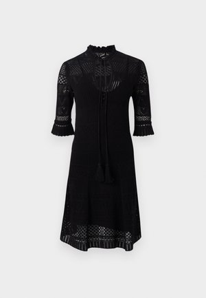Black knit dress featuring a high neckline, three-quarter sleeves with ruffled edges, and a textured pattern throughout. Includes a tie with tassels.