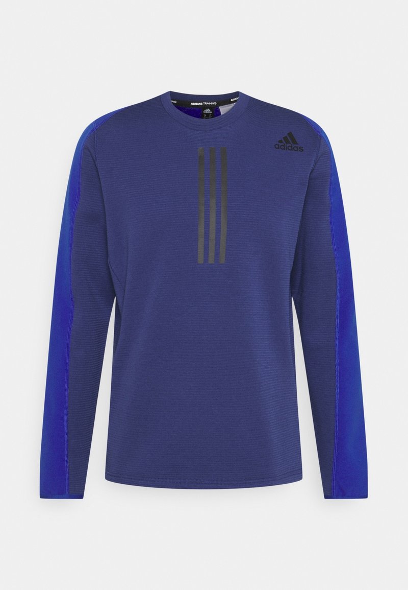 Maglietta atletica a maniche lunghe di colore blu scuro con pannelli laterali in blu chiaro a contrasto. Presenta un design a tre strisce nere sul davanti. Tessuto testurizzato.