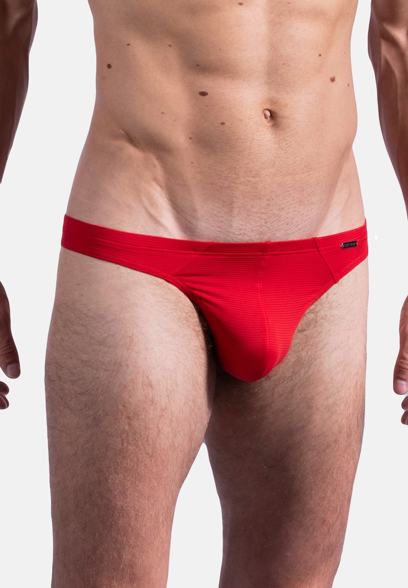 Rote Männerbikini-Briefs mit gerippter Textur, einem glatten Bündchen und minimaler Abdeckung. Mit einem kleinen Markenetikett an der Seite.