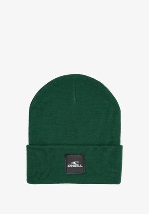 Žalias megztas kepurė su sulenktu kraštu, priekyje esant juodu kvadratiniu pleistru su balta prekių ženklų etikete. Minkšta tekstūra, paprastas dizainas.