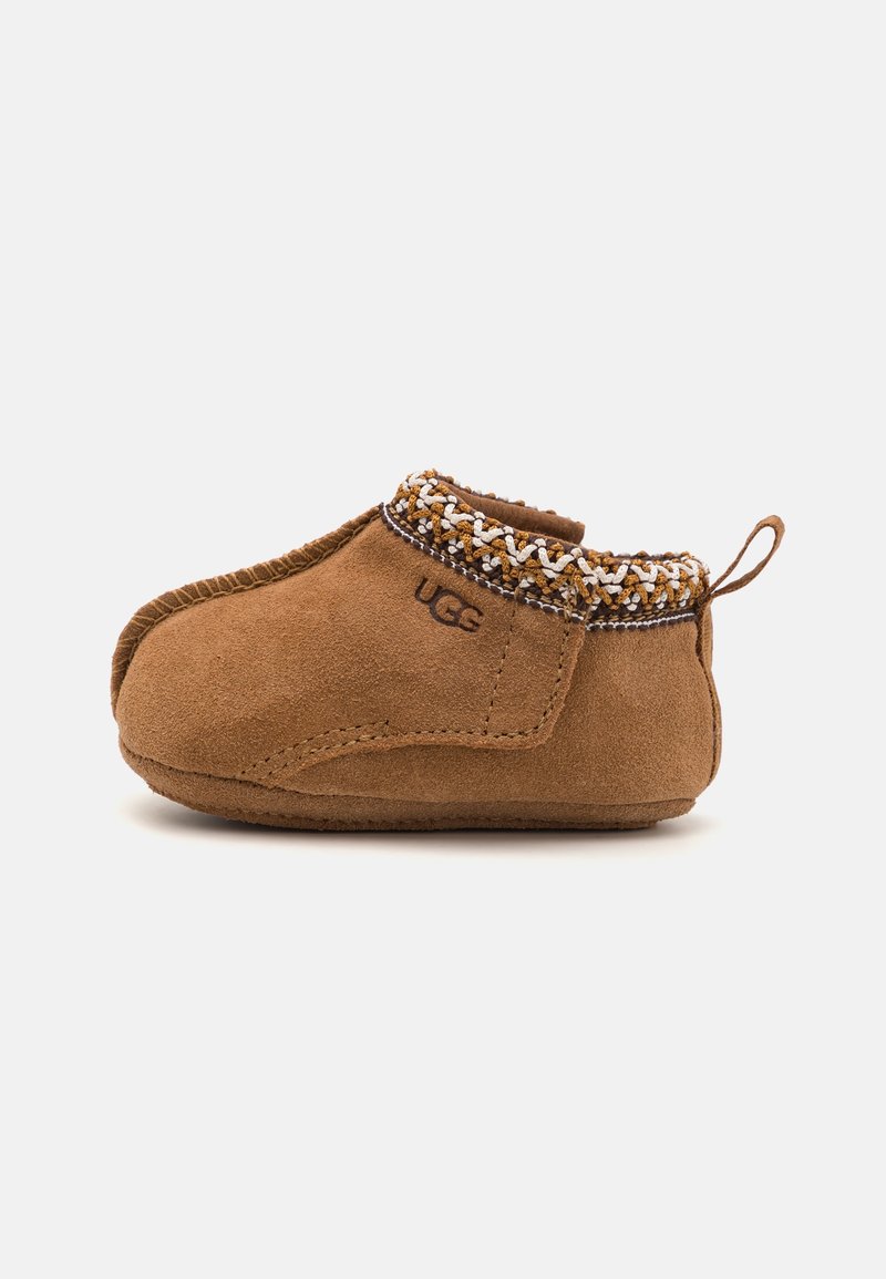 Chaussure bébé en daim marron avec bordure tressée, logo UGG sur le côté et languette au talon, vue du côté droit.