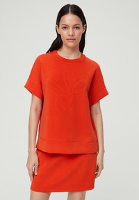 Rode katoenen blend top met korte mouwen, voorzien van een gemêleerd bladpatroon, ronde hals en een relaxte pasvorm, gecombineerd met een bijpassende rok.