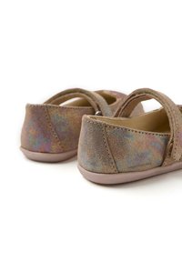 Zapatos marrones con superficie texturizada iridiscente, forma redonda y suela de color rosa suave. Cuentan con una correa en la parte superior para un ajuste seguro.