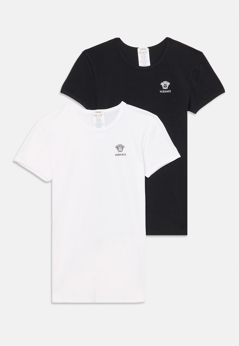 Δύο απλά κοντομάνικα t-shirts Versace, ένα μαύρο και ένα λευκό, κάθε ένα με ένα μικρό λογότυπο κεφαλής Μέδουσας στο αριστερό στήθος.