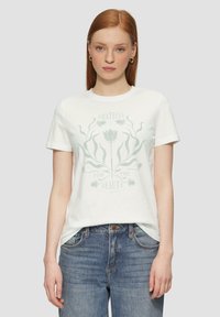 Witte katoenen t-shirt met een groene bloemenontwerp, voorzien van de tekst "DANKBAAR VOOR DE SCHOONHEID", korte mouwen en een klassieke ronde hals.