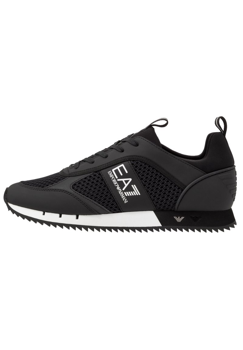 Sneaker nera con pannelli in rete, lacci e suola in gomma bianca. Presenta accenti geometrici e un dettaglio con il logo sul lato. Finitura testurizzata.