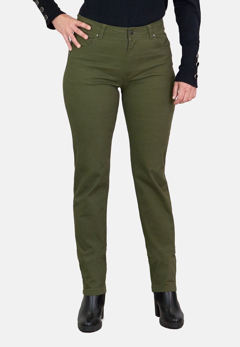 Jeans ajustados de color verde oliva con una textura suave, que presentan un estilo de cinco bolsillos y una cintura de altura media, combinados con botas hasta el tobillo negras.