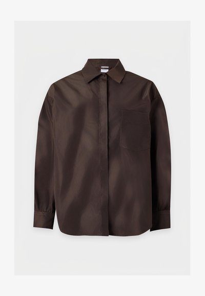 Chemise marron foncé à manches longues avec boutons, col et unique poche poitrine, présentée sur un fond clair uni.