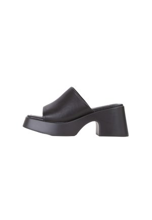 Infradito in pelle nera con una larga fascia sopra il piede, suola piatta elevata e un design del tallone angolare unico.