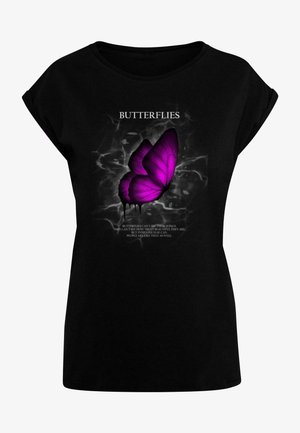 Mustvalge t-särk, millel on suur lilla liblikas ja valged tähtede tekst. Säär on lõdva siluetiga ning lühikeste varrukatega, omades sileda tekstuuri.