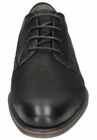 Zapato de vestir de cuero negro con un acabado suave, punta redonda, diseño de cordones y textura sutil. Presenta una suela resistente con acentos marrones.