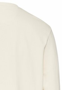 Crème katoenen shirt met lange mouwen, met een ronde hals en een zachte textuur, met een gladde, ongecompliceerde oppervlakte.