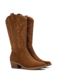 Botas de vaquero de ante marrón con costuras decorativas, punteras afiladas y un tacón apilado. Con tiradores para facilitar su uso.