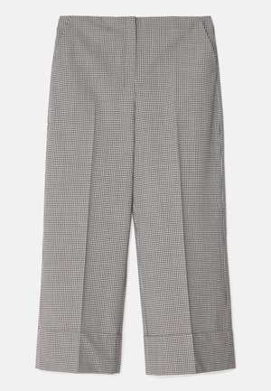 Zwart-wit geblokte broek. Gemaakt van weefsel, met een iets cropped ontwerp en brede manchetten aan de zoom.