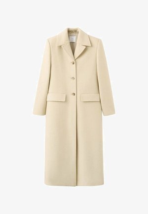 Dlouhý béžový vlněný kabát se šálovým límcem, se třemi knoflíky vpředu a dvěma klopovými kapsami na úrovni boků.
