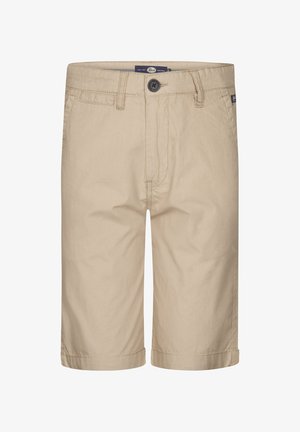 Hvid bomulds t-shirt med "Key West" tryk, beige shorts og hvide sneakers med grønne accenter. Blå-stribede sokker fuldender outfittet.