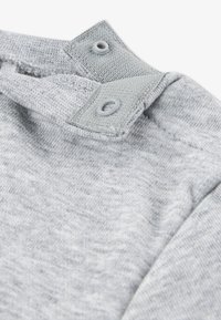 Ύφασμα γκρι πουλόβερ με μαλακή υφή, που διαθέτει ριμπ λαιμόκοψη και κούμπωμα με κουμπιά στο ώμο για εύκολο φόρεμα.