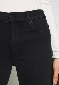 Svarta jeans i denim med en slimmad design, med framknäppning, fem fickor och subtila sömdetaljer.