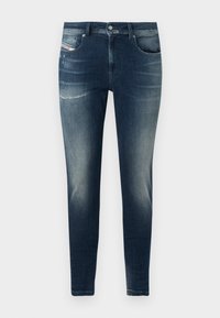 Sötétkék farmernadrág, slim fit szabással, enyhén copfes szemcsés mosással, kissé kopott hatással és klasszikus öt zsebes dizájnnal.