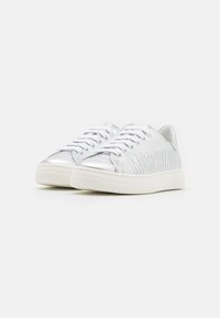 Silvriga lädersneakers med låg topp och vita snören, med präglingen "MOSCHINO" på utsidan och en strukturerad vit gummi sula.